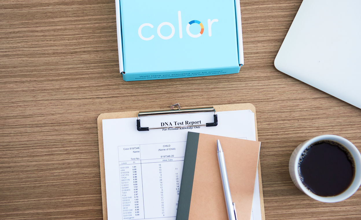 Color test kit, paper with DNA resulst, cup of coffee and notebook all on a desk